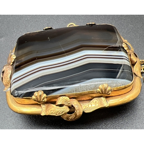 1069 - A large Victorian square shaped banded agate brooch set in an ornate unmarked yellow metal mount. Wi... 