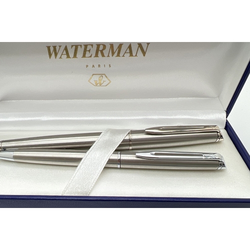 1130 - A boxed Waterman stainless steel cased pen set - fountain pen & ball point pen, together with a box ... 