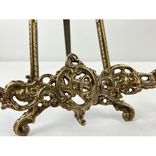 1149 - A pair of bronzed effect metal Regency style table top easel stands with hinged foot. Each approx. 4... 