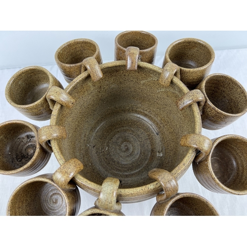 1179 - A vintage studio pottery two tone stoneware large punch bowl with 12 matching cups. Each with 'MW' i... 