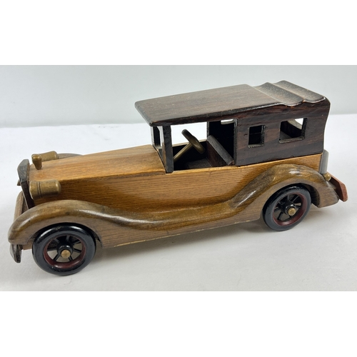 1340 - A vintage wooden model of a classic car with moving wheels, approx. 36cm long.