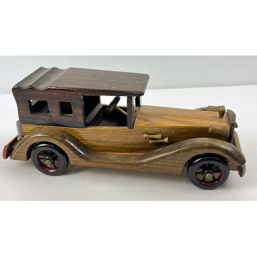 1340 - A vintage wooden model of a classic car with moving wheels, approx. 36cm long.