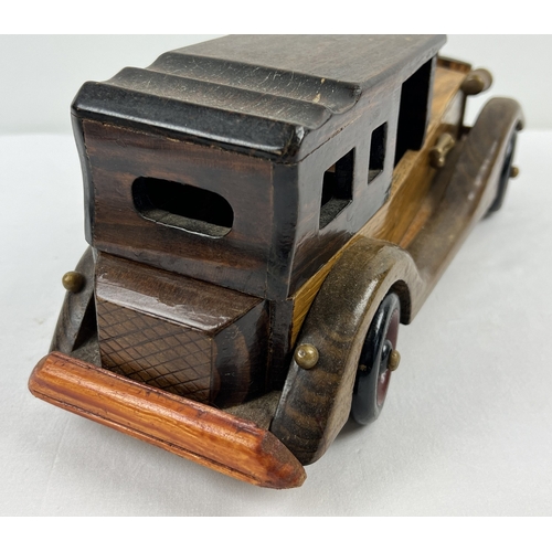 1340 - A vintage wooden model of a classic car with moving wheels, approx. 36cm long.