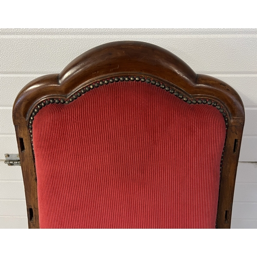 1368 - A large antique shaped high back low armchair with red corduroy velvet upholstery. Peg holes evident... 