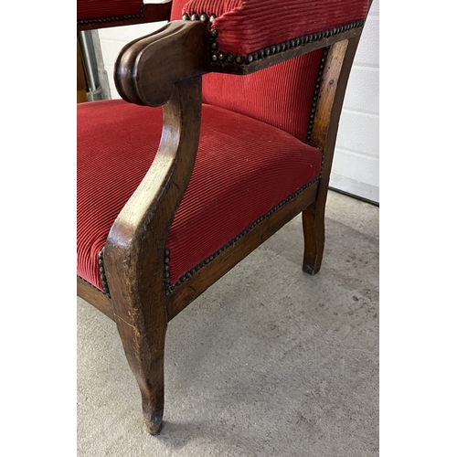 1368 - A large antique shaped high back low armchair with red corduroy velvet upholstery. Peg holes evident... 