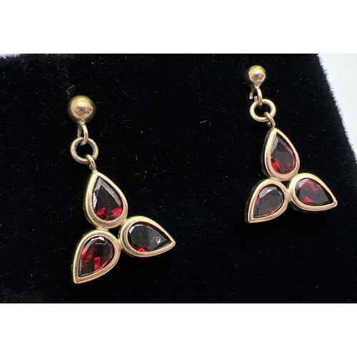 12 - A pair of vintage gold drop style earrings each set with 3 pear cut garnets. Not hallmarked but test... 