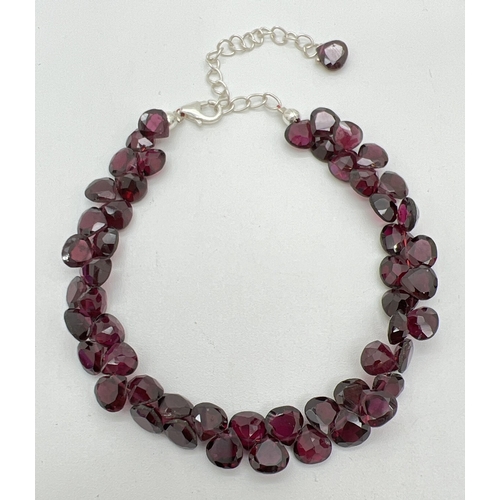 46 - A modern silver and garnet bracelet with extension chain. Body of bracelet made from 52 pear shaped ... 