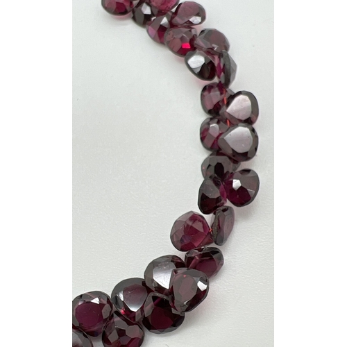 46 - A modern silver and garnet bracelet with extension chain. Body of bracelet made from 52 pear shaped ... 