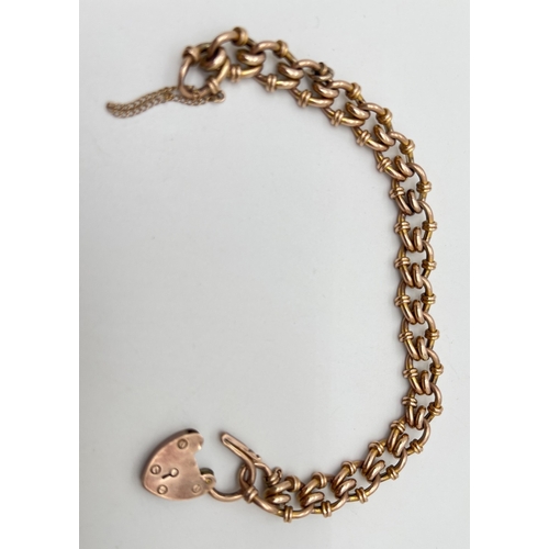 63 - An antique 9ct rose gold decorative link charm bracelet with padlock clasp and safety chain (broken)... 