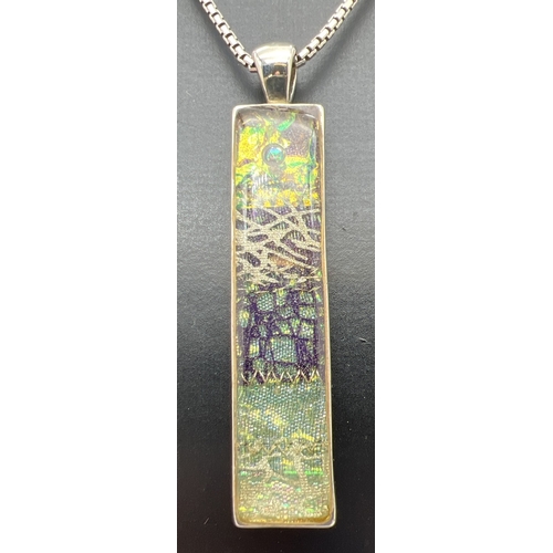 71 - A large foil art glass pendant in green, gold and black tones, on a 15