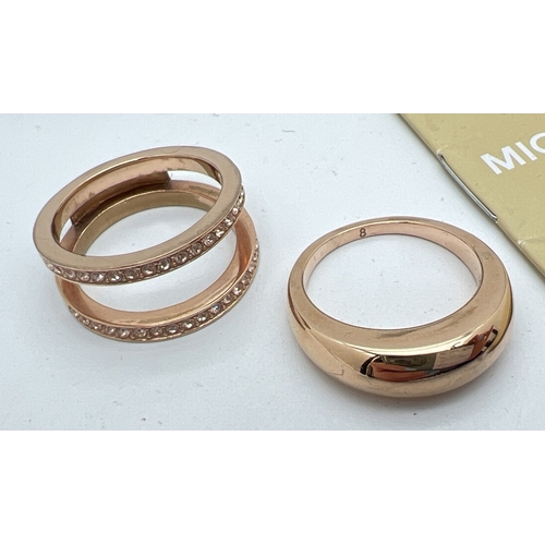 80 - 2 items of Michael Kors jewellery. A gold tone stone set double intertwined band ring set with clear... 