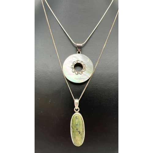 93 - 2 modern design natural stone set pendants on silver chains. An oval cut green agate pendant on a 20... 