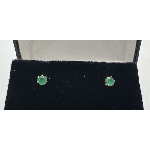 112 - A pair of yellow gold and emerald small stud earrings. Indistinct gold marks to posts, possibly fore... 