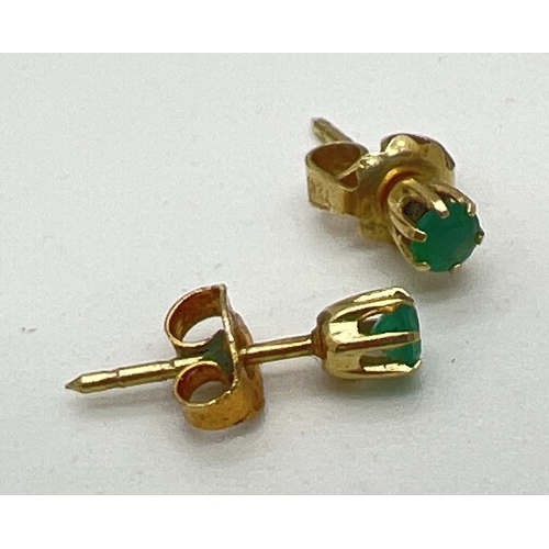 112 - A pair of yellow gold and emerald small stud earrings. Indistinct gold marks to posts, possibly fore... 