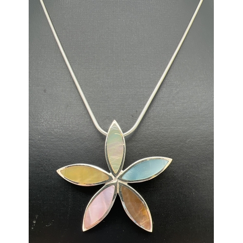 128 - A modern design silver flower shaped pendant set with different coloured mother of pearl, on an 18