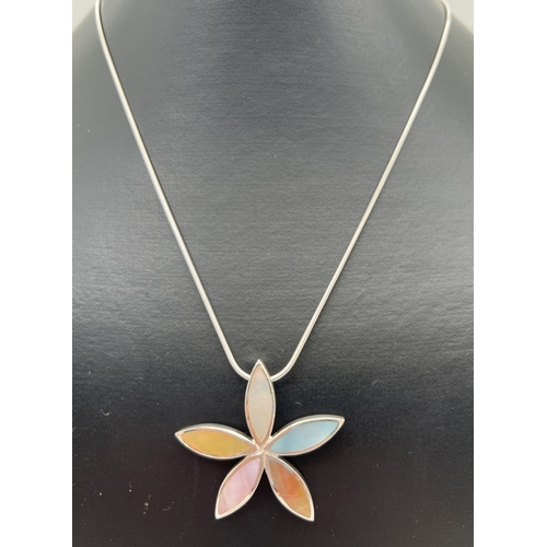 128 - A modern design silver flower shaped pendant set with different coloured mother of pearl, on an 18