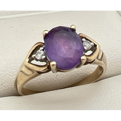 143 - A 9ct gold, amethyst and diamond ring with central oval cut amethyst and a small round cut diamond t... 