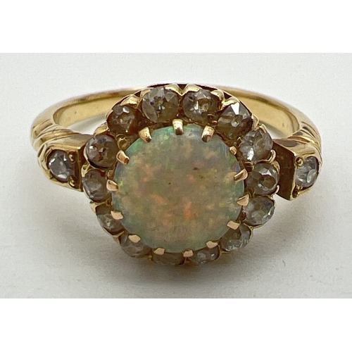 144 - An unmarked yellow gold halo style opal and diamond dress ring. Central round cut opal surrounded by... 