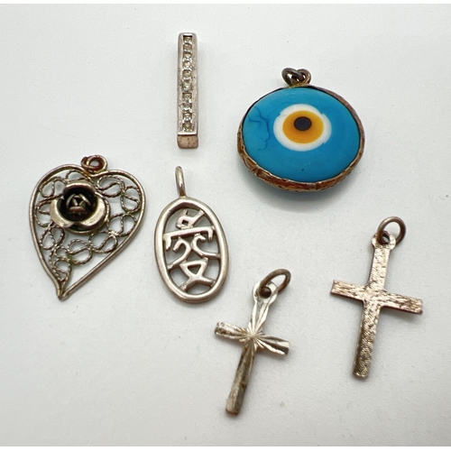 157 - 6 silver and white metal vintage and modern pendants. To include ceramic all seeing eye, filigree he... 