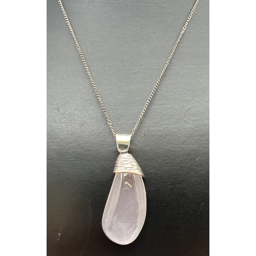 164 - A vintage teardrop cut rose quartz pendant with bark effect silver cap, on a 20