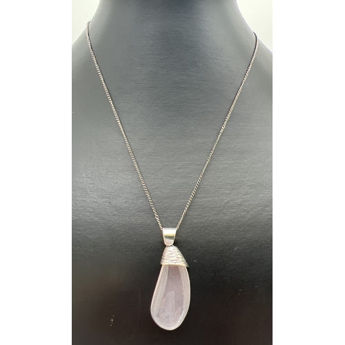 164 - A vintage teardrop cut rose quartz pendant with bark effect silver cap, on a 20