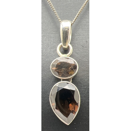 169 - A modern design silver pendant set with oval cut and a pear cut smoked quartz stones. On an 18