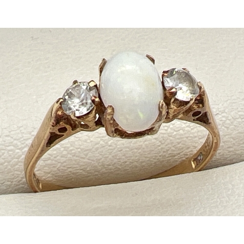 181 - A vintage 18ct gold opal and white topaz dress ring. Central oval cut opal flanked by a round cut wh... 