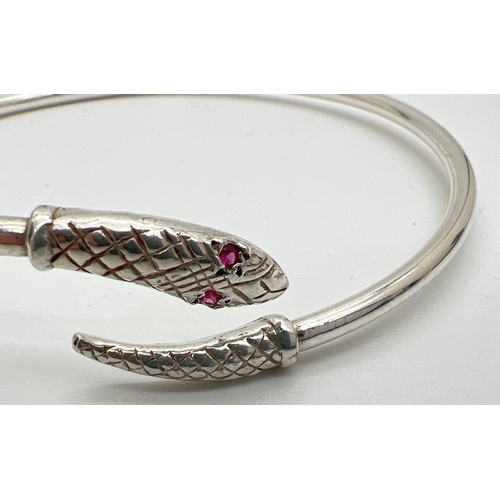 195 - A vintage silver serpent bangle with ruby set eyes. Full hallmarks inside of bangle for Birmingham 1... 