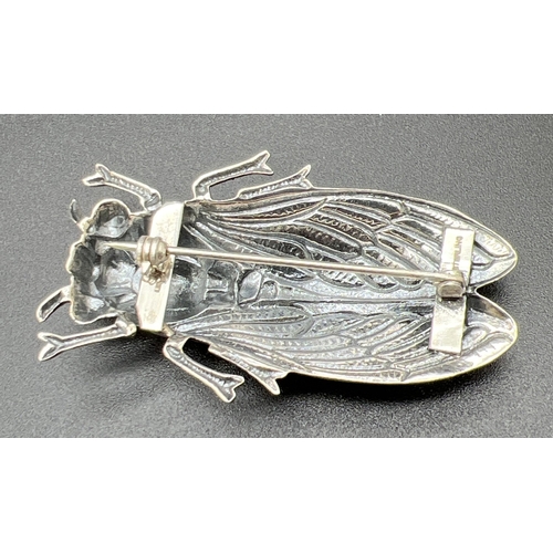 1100 - A large silver brooch modelled as a winged insect, with coloured enamelled detail to wings. Stamped ... 