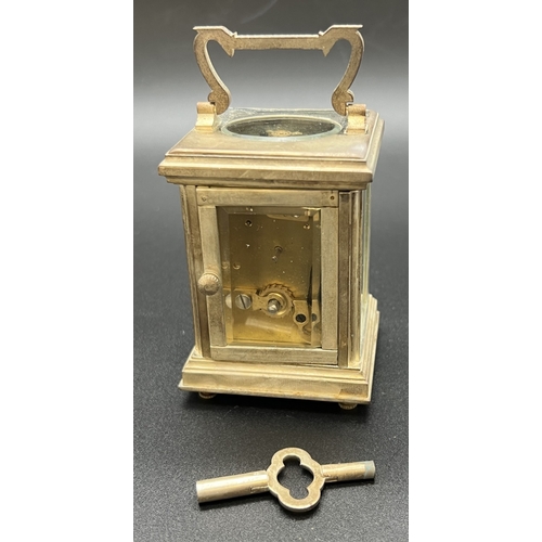 1244 - A small silver plated carriage clock with bevel edged glass panels and enamelled face with Roman Num... 