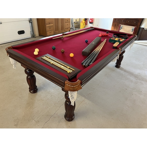 An 8ft x 4ft solid mahogany slate bed Pool/Snooker and Dining table. With Windsor red cloth and turned leg detail. Together with a 2 piece veneered Dining table top and table protector sheet. With all accessories pool/snooker balls, cues & rest, cloth brush, two triangles, score board and cue rest wall bracket.
