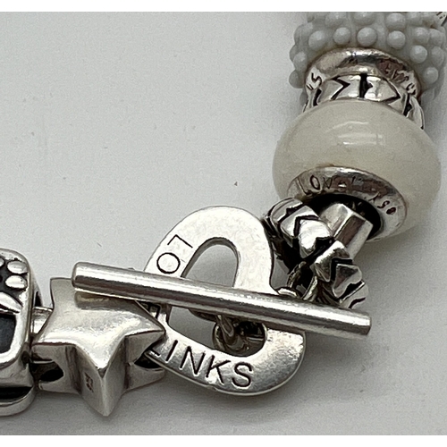 1007 - A Love Links silver charm bracelet with 22 silver and glass charms and with T bar and heart shaped c... 