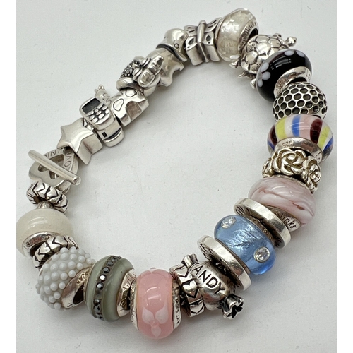 1007 - A Love Links silver charm bracelet with 22 silver and glass charms and with T bar and heart shaped c... 