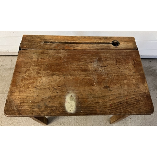 1353 - A vintage wooden child's desk with lift up lid, inkwell hole and pen tray. Raised on square legs. Ap... 