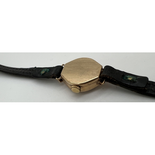 1129 - A ladies vintage 9ct gold cased wristwatch by Relide, with black leather strap. Hallmarked inside ca... 