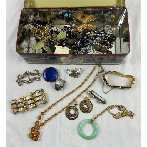 1050 - A tin of assorted vintage costume jewellery to include a silver Ruskin Pottery blue coloured brooch,... 