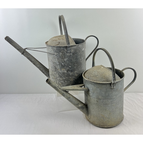 1206 - 2 vintage galvanised watering cans with hooped handles. A 2 gallon can together with a 1½ gallon can... 