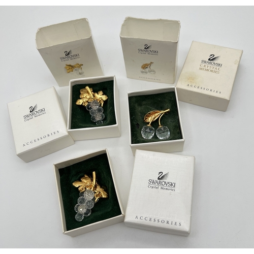 1067 - 3 boxed Swarovski crystal and gold tone brooches from the Crystal memories range. A double cherry br... 