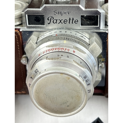 1285 - A vintage Braun Super Paxette camera with extra lens and accessories and instruction booklets, in br... 