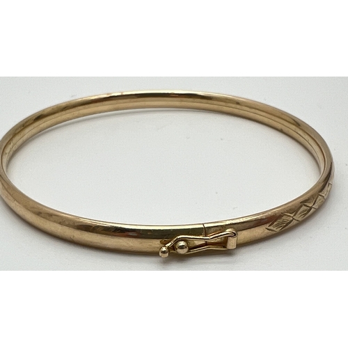 1087 - A 9ct yellow gold bangle with engraved diamond design to half. Push clasp and safety clip. Fully hal... 