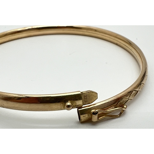 1087 - A 9ct yellow gold bangle with engraved diamond design to half. Push clasp and safety clip. Fully hal... 