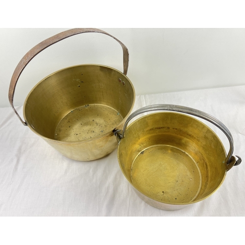 1215 - 2 vintage heavy brass jam pans. A large pan with riveted fixed hoop handle (approx. 34cm diameter) t... 