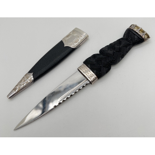 1178 - A boxed 20th century Scottish silver mounted Sgian Dubh with carved black wood hilt set with large o... 