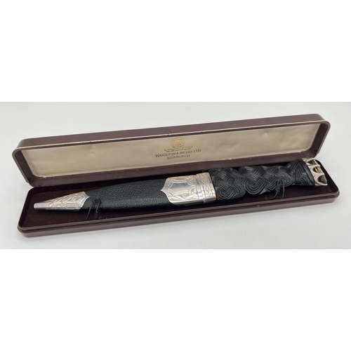 1178 - A boxed 20th century Scottish silver mounted Sgian Dubh with carved black wood hilt set with large o... 