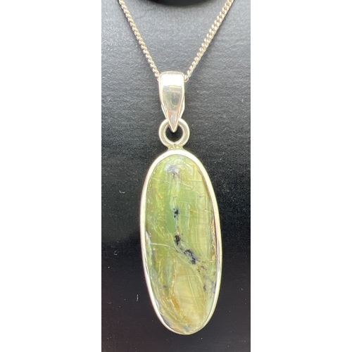 93 - 2 modern design natural stone set pendants on silver chains. An oval cut green agate pendant on a 20... 
