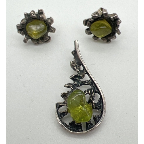 123 - A vintage 1970's silver and peridot pendant and matching stud style earrings. All with bark effect d... 