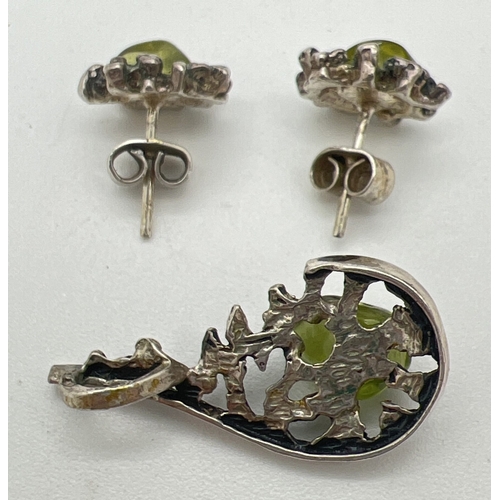 123 - A vintage 1970's silver and peridot pendant and matching stud style earrings. All with bark effect d... 