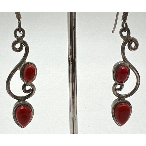 1025 - A silver stone set pendant and earrings. A pair of 925 silver drop style earrings with scroll decora... 