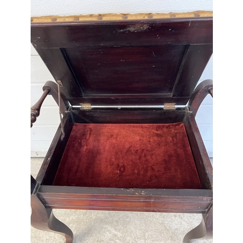 1323 - A Victorian mahogany piano stool with cabriole style legs, turned handles and lift up upholstered se... 