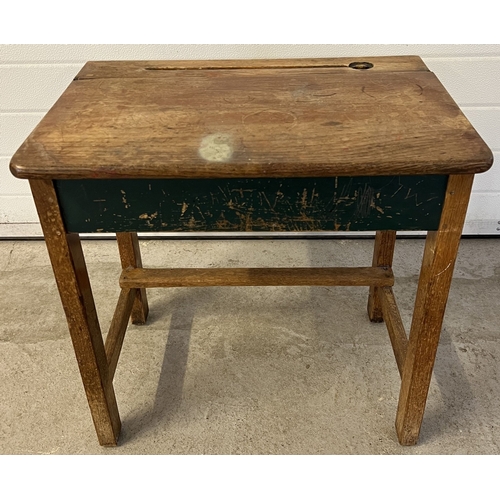 1353 - A vintage wooden child's desk with lift up lid, inkwell hole and pen tray. Raised on square legs. Ap... 